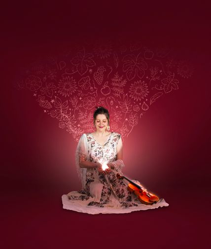 Sitzende Frau mit Geige vor sich liegend. Die Frau hält ein Licht in beiden Händen, welches sie anstrahlt. Roter floraler Hintergrund.