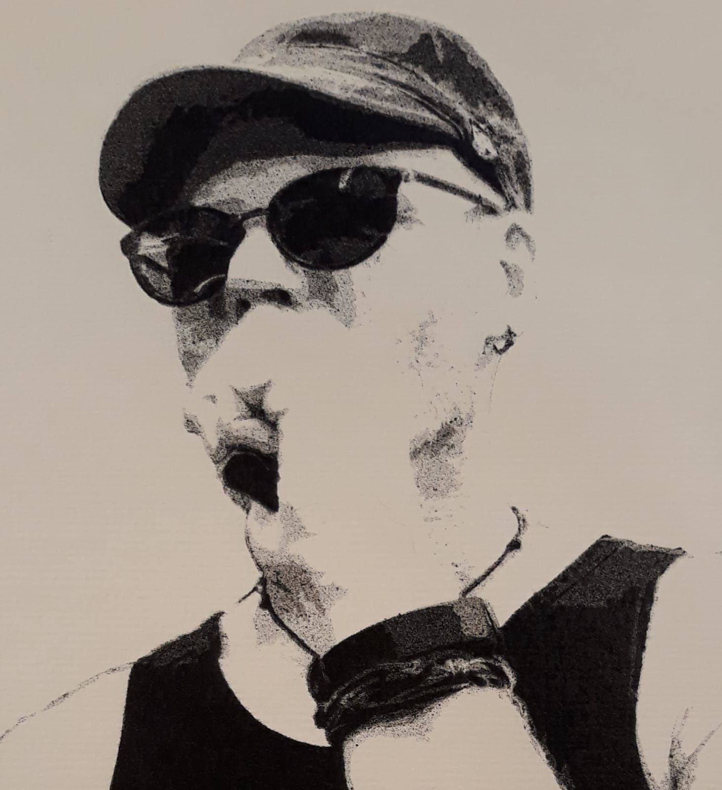 Schwarz-weiß Porträt einer Person mit Sonnenbrille und Mütze, die eine Hand vor den Mund hält. Die Person trägt ein ärmelloses Oberteil.