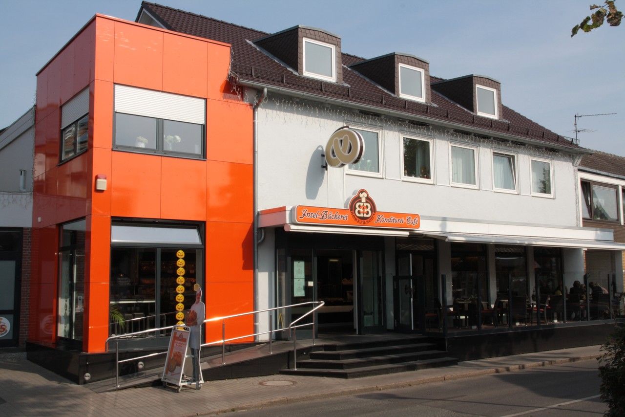Die Inselbäckerei Börke & Sohn in der Osterstraße zeigt einen modernen, orangefarbenen Anbau neben dem traditionellen Gebäude.