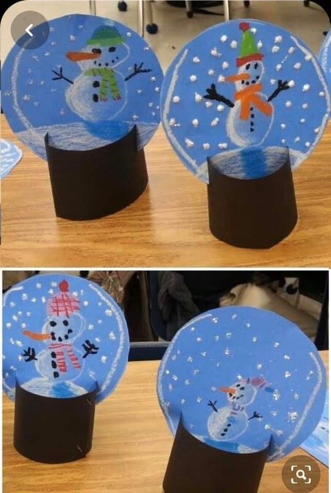 Selbstgebastelte Schneekugeln mit Schneemännern aus Papier stehen auf einem Tisch. Die Schneemänner tragen bunte Hüte und Schals.