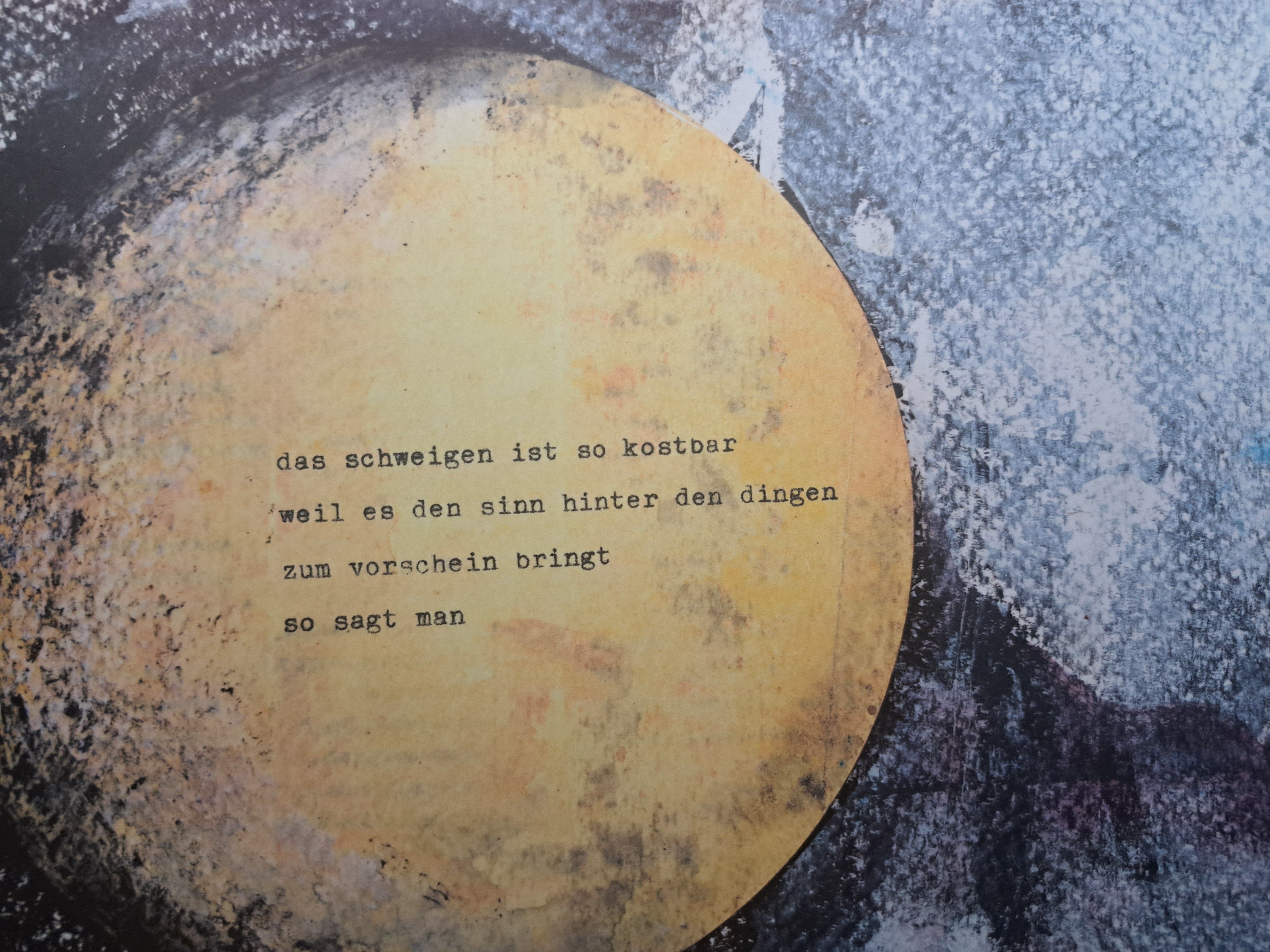 Ein gelber Kreis mit einem poetischen Text auf einem abstrakten, strukturierten Hintergrund.