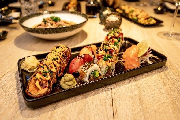 asiatische Fisch-Reis-Rollen auf einem Teller angerichtet