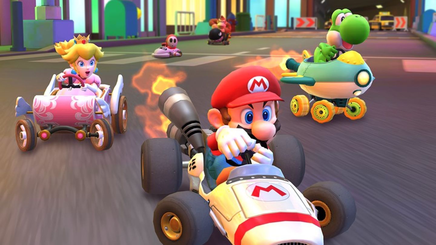 Mario, Peach und Yoshi rasen in ihren Karts über eine bunte Rennstrecke in Mario Kart. Die Szene zeigt Action und Geschwindigkeit.