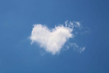 Herzförmige Wolke am blauen Himmel zum Valentinstag.
